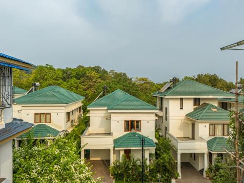 a row of houses with green roofs at ELIVAAS 3 BHK with Pvt Pool - Azalea in Siolim