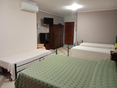 a hotel room with two beds and a television at Mamma Assunta in Melendugno