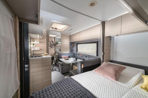 a bedroom of an rv with a bed and a sink at VogtlandCAMPING in Markneukirchen