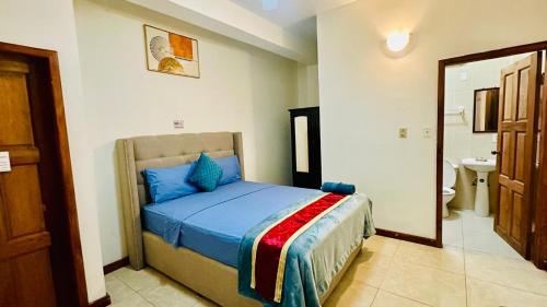 a bedroom with a bed and a bathroom with a mirror at San Pedro Ocean Paradise in San Pedro
