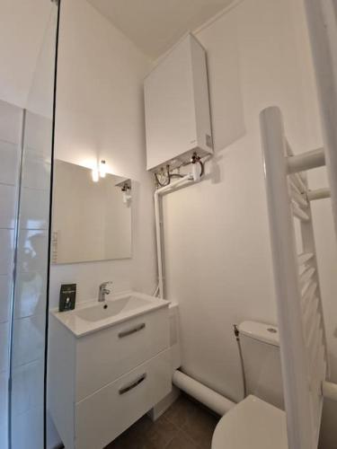 une salle de bain blanche avec un lavabo et des toilettes dans l'établissement Maison avec accès au jardin - très proche sites JO, à Pierrefitte-sur-Seine