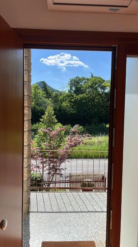 a door leading to a patio with a view of a park at Appartamento Camera'n Montegrotto Terme in Montegrotto Terme
