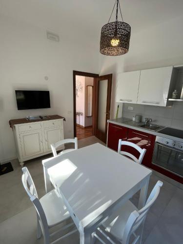 a kitchen with a white table and white chairs at Appartamento Camera'n Montegrotto Terme in Montegrotto Terme
