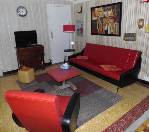 een woonkamer met een rode bank en een tafel bij Vintage in Perpignan in Perpignan