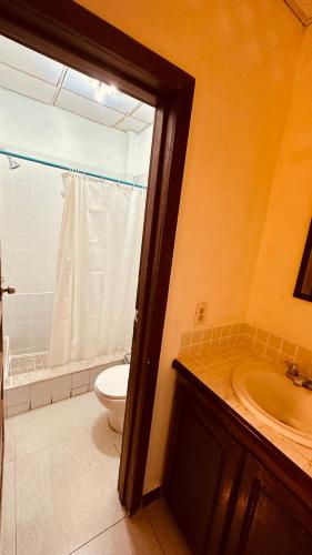a bathroom with a toilet and a sink at San Pedro Ocean Paradise in San Pedro