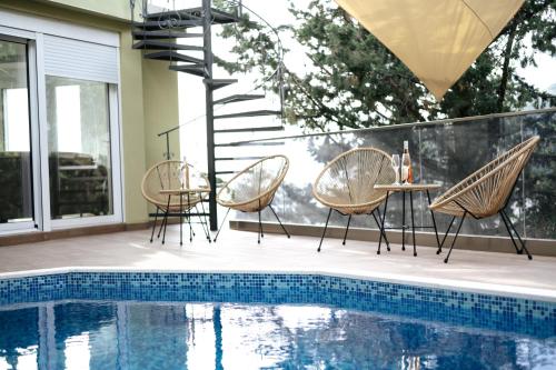 a patio with chairs and a table next to a pool at Resort Stikovic in Dobra Voda