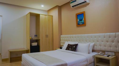 a hotel room with a bed with a white bedspread at Grand Vistana in Dhaka