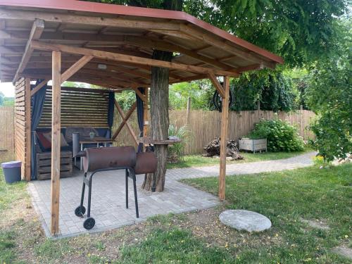a wooden gazebo with a chair under it at Sklípek-chatka Bella Moravia in Dobré Pole