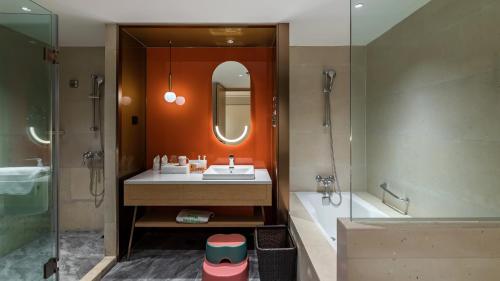 a bathroom with a sink and a shower and a mirror at Holiday Inn Chongqing Guanyinqiao by IHG in Chongqing