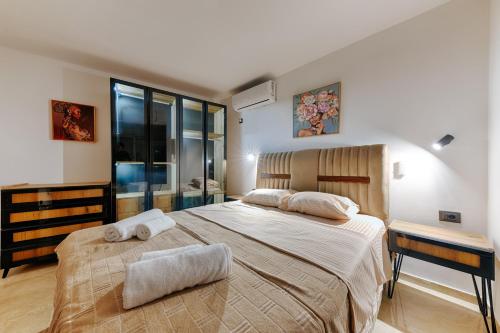 a bedroom with a large bed with towels on it at Resort Stikovic in Dobra Voda