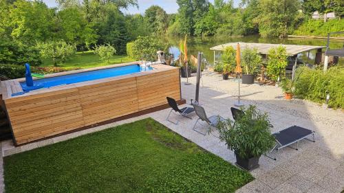 un patio trasero con una piscina con sillas y una mesa en River Houses Ljubljanica en Liubliana