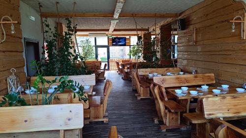 un restaurant avec des tables en bois, des chaises et des plantes dans l'établissement Pokoje Dom Turysty Sanok 24h, à Sanok