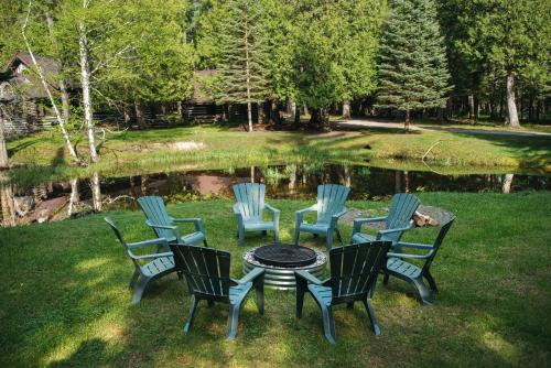 トラバースシティにあるNatures Beauty at Forks River 1BDR with Loft Lodge 8895の池の前の椅子とテーブル