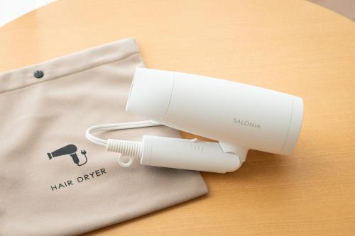 a white hair dryer sitting on top of a table at EN RESORT Kumejima EEF Beach Hotel in Kumejima