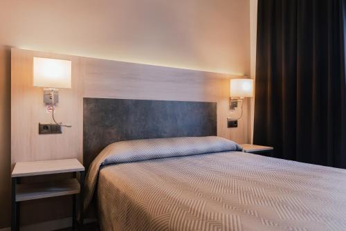 um quarto de hotel com uma cama e duas luzes em Port Fiesta Park em Benidorm