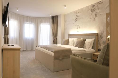 a hotel room with a bed and a chair at Bracera Inn in Malinska