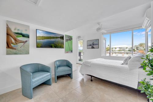 um quarto com uma cama, uma cadeira e uma janela em Suite by Beach Waterfront Lago Key Two em Fort Lauderdale