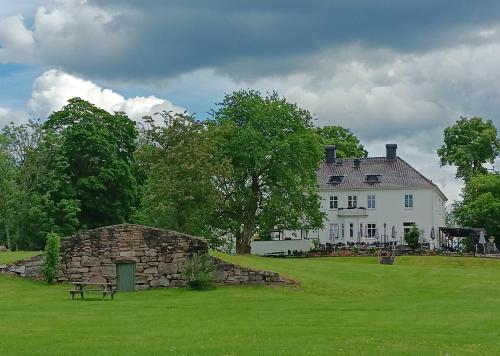 a large white house with a bench in the grass at Ferienhaus Schweden - Hus Else in Gällstad