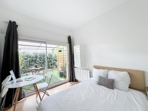 een slaapkamer met een bed, een tafel en een raam bij Domaine Le Clos Lassagne in Brignais