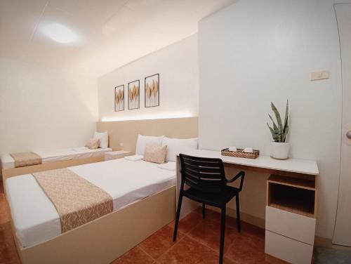 a bedroom with a bed and a desk and a chair at Kaimito House - Guest House near Mactan-Cebu Airport in Lapu Lapu City
