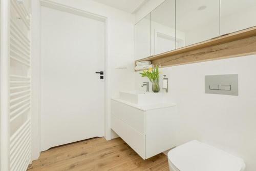 a white bathroom with a toilet and a sink at Apartment in Pobierowo near Baltic Beach in Pobierowo