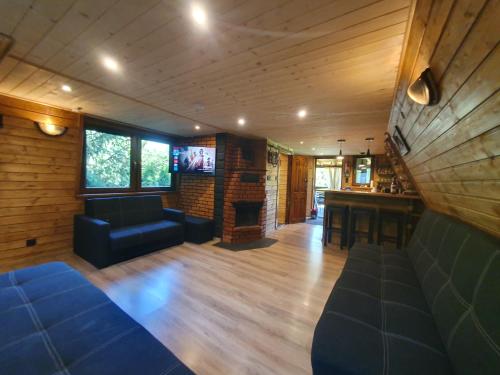a living room with a couch and a fireplace at RESET W WERLASIE- Domek na wyłączność- kajak w cenie in Werlas