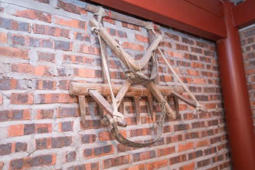 un vélo suspendu sur un mur de briques dans l'établissement Milk Milk Homestay, à Yên Minh