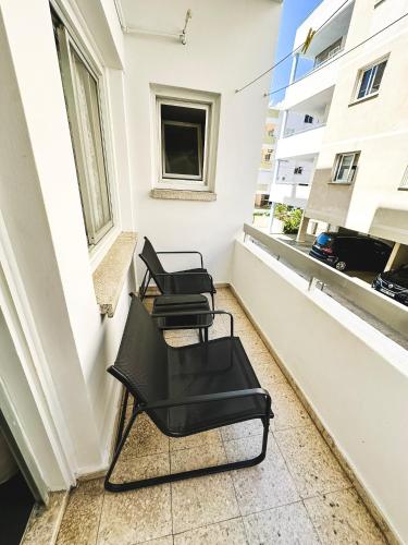 three chairs sitting on the balcony of a building at Home Away One Bedroom Apartment in Nicosia in Nicosia