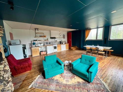 uma sala de estar com duas cadeiras e uma cozinha em Lapland Old School em Muonio