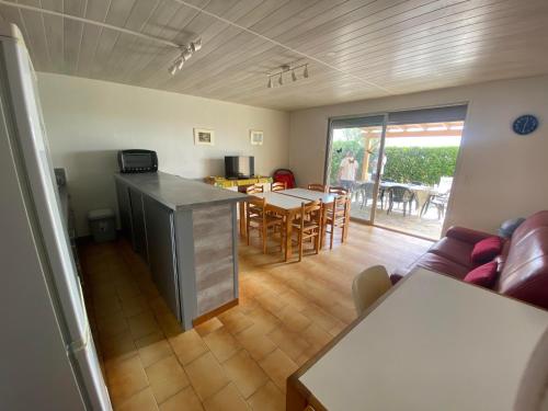 un salon avec une cuisine et une salle à manger dans l'établissement Appart rdc accès direct plage, 8ARIST8, au Barcarès