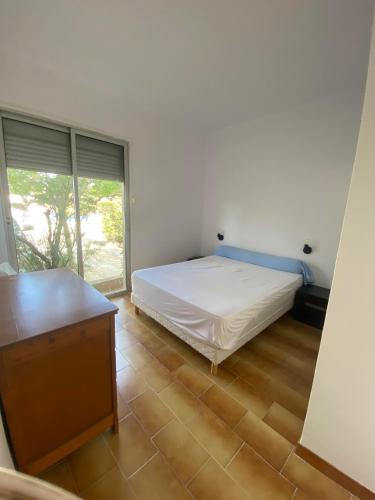 une chambre avec un lit et une grande fenêtre dans l'établissement Appart rdc accès direct plage, 8ARIST8, au Barcarès