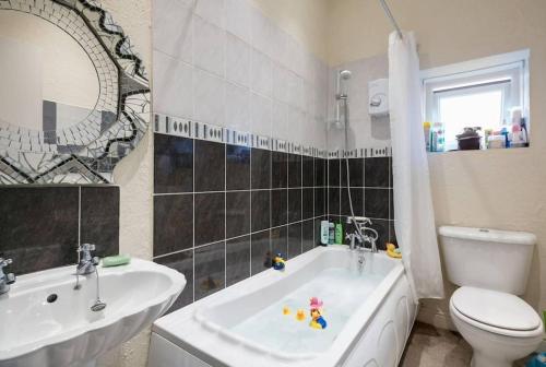 a bathroom with a tub and a toilet and a sink at Bradford Digs self contained house in Bradford