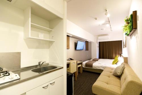 a room with a kitchen and a bedroom with a bed at President Hotel Hakata in Fukuoka