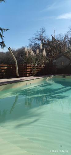 a swimming pool with a clear blue water at B&B En plein coeur de la forêt in Artiguelouve