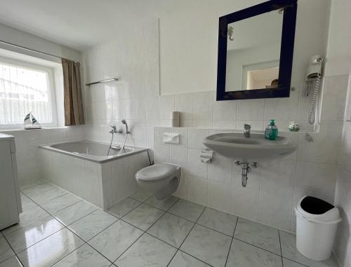 a bathroom with a tub and a toilet and a sink at Ferienhaus Schmidt in Storkow