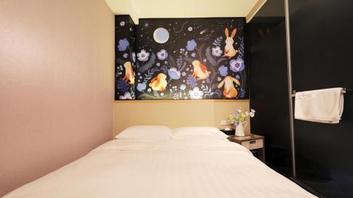 a bedroom with a bed with a painting above it at RF Hotel  Linsen in Taipei