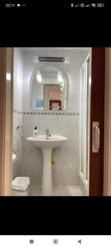 a bathroom with a sink and a toilet and a mirror at Hogar calido calafell in Calafell