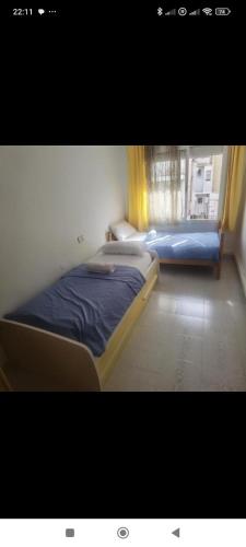 a bedroom with two beds and a window at Hogar calido calafell in Calafell