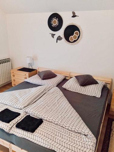 two beds in a bedroom with hats on the wall at Apartman Rendulić in Ogulin