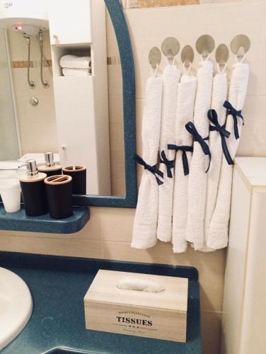 a bathroom with a rack of towels and a mirror at Apartman Rendulić in Ogulin