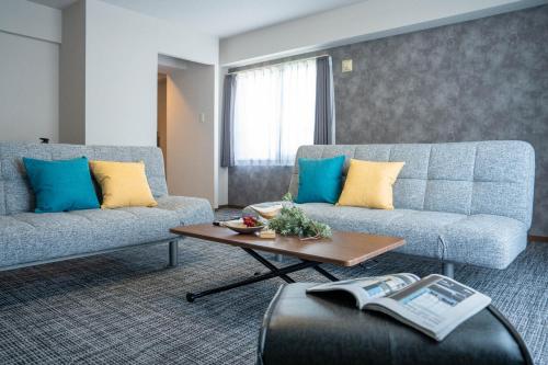 a living room with two couches and a coffee table at MP STYLE Fortuna in Sapporo