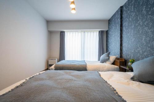 a bedroom with two beds and a window at MP STYLE Fortuna in Sapporo