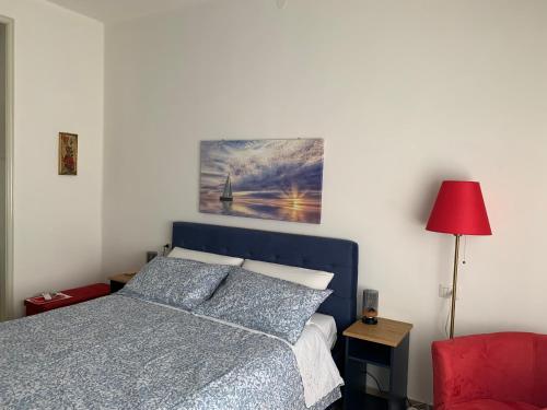 a bedroom with a blue bed and a red chair at Affittacamere Le Rose in Imola