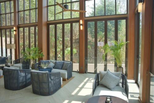 a lobby with couches and tables and windows at The Proud Karon Beach Phuket Trademark Collection By Wyndham in Karon Beach