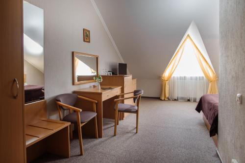 een slaapkamer met een bureau, een bed en een spiegel bij Курортний комплекс Santa Maria in Skhidnitsa