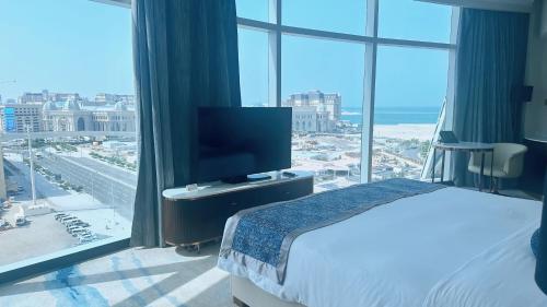 a hotel room with a bed and a large window at Century Marina Hotel - Lusail in Lusail