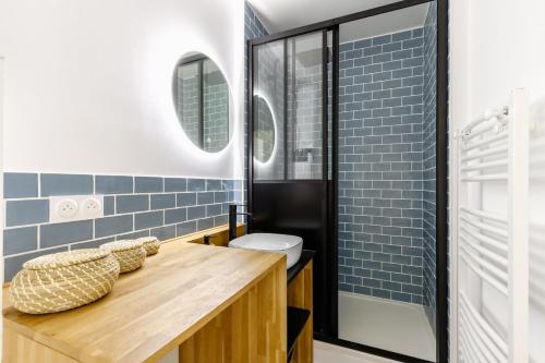 une salle de bain avec un comptoir en bois et du carrelage bleu dans l'établissement L'estacade - charmant studio proche de la mer, à Saint-Jean-de-Monts