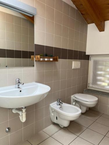 a bathroom with a sink and a toilet at Ostello Casa Rossa in Laveno-Mombello