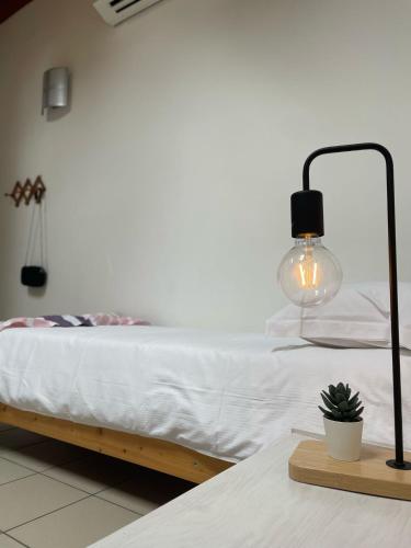 a bedroom with a bed with a lamp on a table at Ostello Casa Rossa in Laveno-Mombello