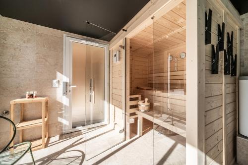 un sauna avec des portes vitrées et des chaises dans une pièce dans l'établissement Ô songes de Saxel, à Saxel